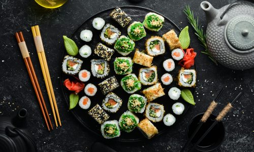 Set of traditional sushi on a black plate. Sushi and rolls on a dark background.