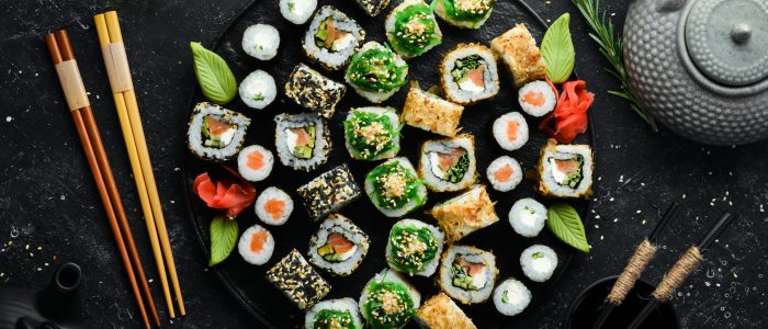 Set of traditional sushi on a black plate. Sushi and rolls on a dark background.