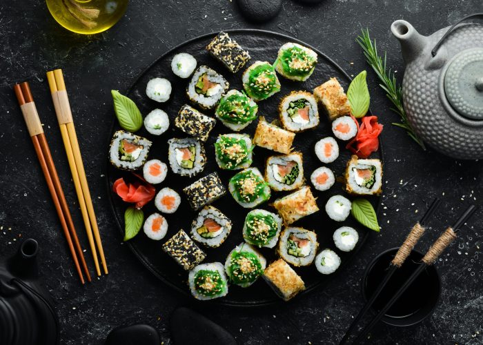 Set of traditional sushi on a black plate. Sushi and rolls on a dark background.